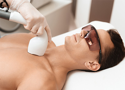 The image shows a person lying on a massage table with a device placed on their chest, receiving what appears to be an infrared or heat therapy session.